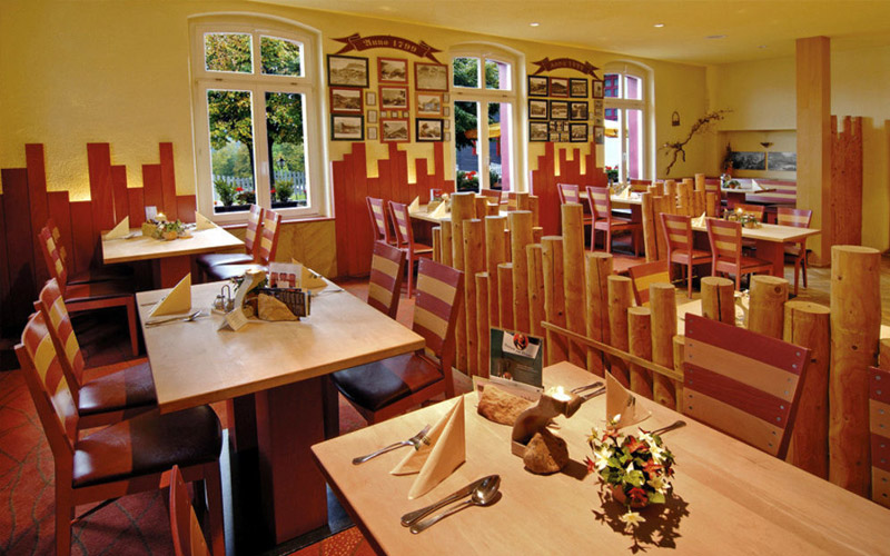 Genuss mit Ausblick – die Gastronomie im Panoramahotel Lilienstein verwöhnt mit regionaler Küche und herrlichem Blick über die Sächsische Schweiz. Restaurantbereich im Panoramahotel Lilienstein mit Panoramafenstern, gedeckten Tischen und Blick auf die Landschaft der Sächsischen Schweiz.