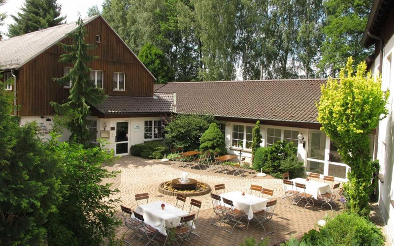 Idyllisches Land-gut-Hotel Zur Lochmühle in Penig – traditioneller Charme nahe Chemnitz Außenansicht des Land-gut-Hotels Zur Lochmühle in Penig mit Fachwerkfassade und grüner Umgebung, nahe Chemnitz