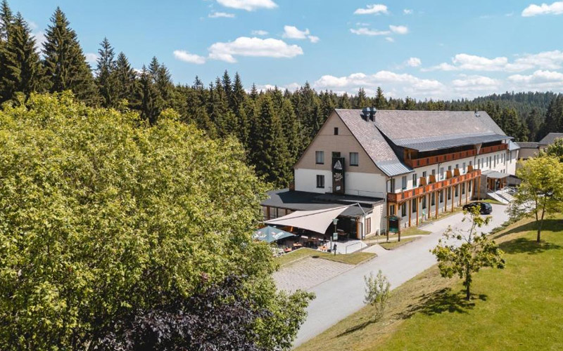 Waldhotel Vogtland in Klingenthal – naturnahes Wohlfühlhotel mitten im Grünen des sächsischen Vogtlands Gemütlicher Gasthof mit Landhotel in Klingenthal-Zwota, traditionelles Gebäude mit einladender Terrasse inmitten der Natur des Vogtlands